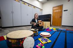 音乐 therapy student sitting behind a row of instruments