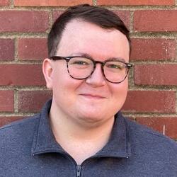 Edward standing in front of a brick wall